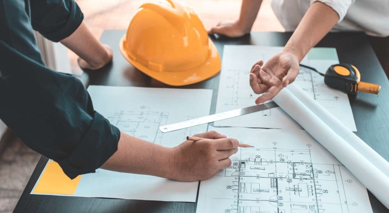 Meeting of engineers and architects in building planning, Consulting and brainstorming experts in architectural planning using blueprints, tape measure, rulers, laptop in designing buildings.